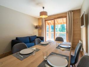 a dining room with a table with chairs and a blue couch at Appartement Valmorel, 3 pièces, 6 personnes - FR-1-291-1003 in Valmorel