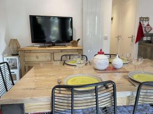 un tavolo in legno con sedie e una televisione in cima di Appartement Risoul, 1 pièce, 5 personnes - FR-1-330-568 a Risoul