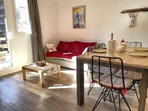 sala de estar con mesa y sofá rojo en Appartement Risoul, 1 pièce, 5 personnes - FR-1-330-568, en Risoul