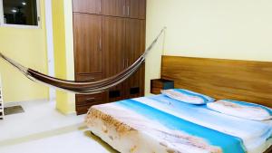 Chicxulub Puerto Beach Penthouse في تشيكشولوب: سرير مع أرجوحة في غرفة النوم