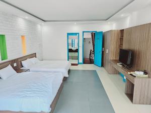 a hotel room with two beds and a television at An's Family Homestay Hoi An - 5mins walk to Hoi An Ancient Town in Hoi An