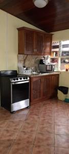 a kitchen with wooden cabinets and a stove top oven at Casa Mora in Jacó