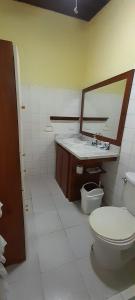 a bathroom with a toilet and a sink and a mirror at Casa Mora in Jacó