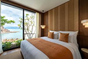 a bedroom with a large bed and a large window at Cape Fahn Hotel - Private Islands Samui in Choeng Mon Beach