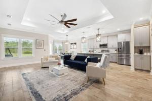 a living room with a blue couch and a kitchen at Laguna Beach House with a Game Room in Panama City Beach