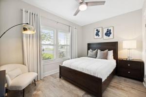 um quarto com uma cama, uma cadeira e uma janela em Laguna Beach House with a Game Room em Panama City Beach