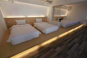 a hotel room with two beds and a mirror at Sovereign Group Hotel at Pratunam in Bangkok