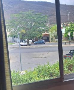 una ventana con vistas a una calle con coches en la carretera en Amelí Alojamiento en Salta
