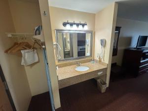 y baño con lavabo y espejo. en Americas Best Value Inn Saint Robert/Fort Leonard Wood en Saint Robert