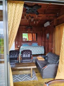 un soggiorno con divano e letto di Casa Torre Eco- Lodge a Fortuna