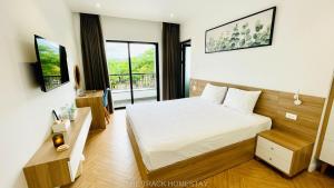 een hotelkamer met een bed en een televisie bij The Track Homestay in Cam Lâm