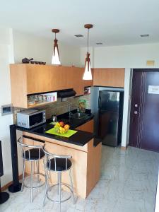 a kitchen with a counter with two bar stools at Luxury Budget Condo in Central Cebu in Cebu City