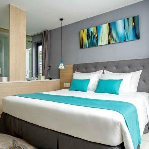 um quarto com uma cama grande e almofadas azuis e brancas em Lovely Room Oceanami Resort em Long Hai