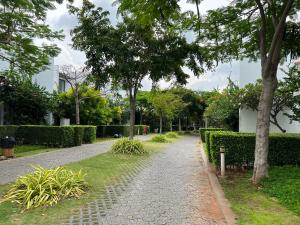 um caminho de paralelepípedos num parque com árvores e arbustos em Lovely Room Oceanami Resort em Long Hai