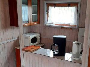 a small kitchen with a counter with a microwave at Holiday cottages for 4 people, Rusinowo in Rusinowo