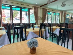 una sala da pranzo con tavoli, sedie e finestre di Mixay Paradise Hotel a Vientiane