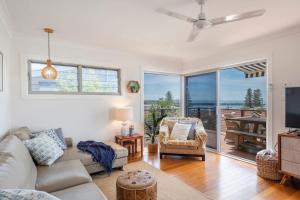 a living room with a couch and a tv at Bimbajong Yamba - oceanstays in Yamba