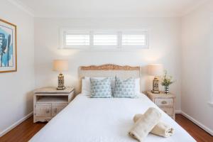 a bedroom with a white bed with blue pillows at Bimbajong Yamba - oceanstays in Yamba
