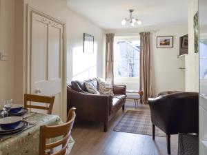 a living room with a couch and a table at Hunters Cottage - Uk44956 in Pooley Bridge