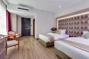 a hotel room with two beds and a desk at New York Hotel in Phnom Penh