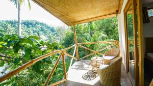 a balcony with chairs and a view of the forest at Serenity Hotel in El Nido