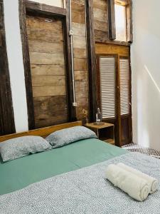 a bedroom with a bed with a wooden wall at KALINDA HOMEY in Karimunjawa