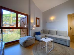 een woonkamer met een bank en een tafel bij Impresionante Ático 3 Habitaciones - 6PAX - Vistas Valle Soldeu - Free Parking - Wifi - Netflix in Incles