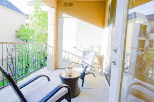 a patio with two chairs and a table on a balcony at Luxury condo near Irvine Business & UCI Hospital in Irvine