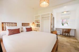 a bedroom with a large white bed in a room at The Room Padang-Padang in Uluwatu