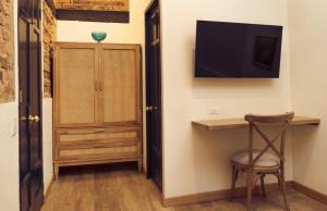 a room with a desk and a television on the wall at Las Aguas Inn in Bogotá