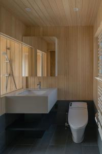 uma casa de banho com um lavatório branco e um WC. em The VILLA SHUN em Otaru