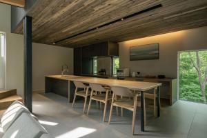 a kitchen with a large wooden table and chairs at The VILLA SHUN in Otaru