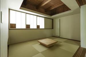 ein leeres Zimmer mit einem Tisch und einem Fenster in der Unterkunft The VILLA SHUN in Otaru