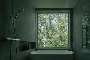 uma casa de banho com uma banheira e uma janela em The VILLA SHUN em Otaru