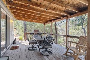um alpendre coberto com uma mesa e cadeiras em Newly Renovated Retreat on 6 Acres, Discover Murphys Lodge with Scenic Views! em Murphys