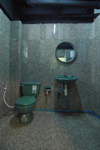 a bathroom with a green toilet and a mirror at GO INN The Grand Palace - โกอินน์ พระบรมมหาราชวัง-วัดพระแก้ว in Bangkok