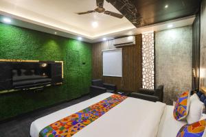 a bedroom with a bed and a green wall at FabHotel Greenstar Inn in Bhubaneshwar