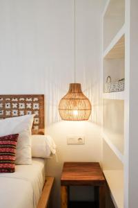 a bedroom with a bed with a table and a lamp at The Room Padang-Padang in Uluwatu