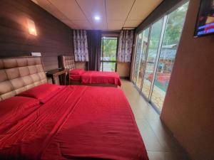 a hotel room with two beds and a window at Tamara Private Pool in Tioman Island