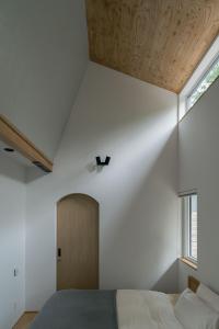 小樽市にあるThe VILLA KAORUの白い壁のベッドルーム1室(ベッド1台、窓付)