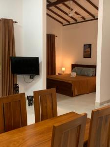 a bedroom with a bed and a television and a table at Wasa Villa in Kalutara