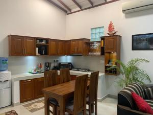 a kitchen with wooden cabinets and a wooden table at Wasa Villa in Kalutara