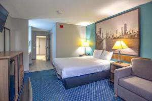 a hotel room with a bed and a couch at Super 8 by Wyndham Rockford in Rockford