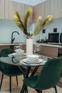 una mesa de comedor con sillas verdes y una cocina en Green with Envy-Luxury Apartment- No Loadshedding, en Johannesburgo