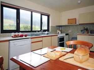 a kitchen with a wooden table with a bread on it at Gors Y Gader in Llanelltyd