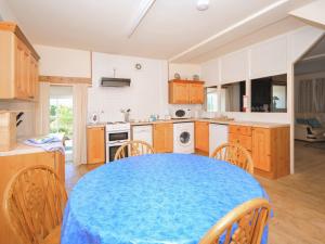 a kitchen with a blue table and chairs in it at Arthfan in Llanelltyd