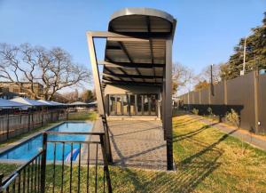 a tennis court with a net next to a pool at Green with Envy-Luxury Apartment- No Loadshedding in Johannesburg
