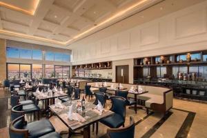 ダナンにあるAltara Luxury Seaview in Four Point by Sheraton- 15 Floor 2 Bedroomのテーブルと椅子のあるレストラン、バー
