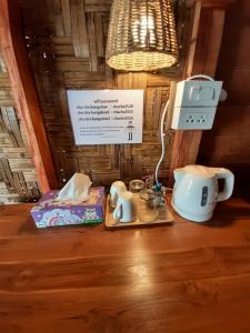 einem Tisch mit zwei Teesorten und einer Lampe in der Unterkunft Cha Cha Bungalow in Ko Jum
