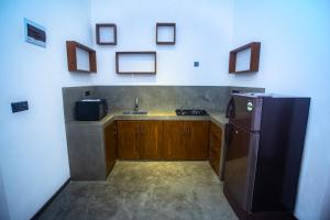 a kitchen with a black refrigerator and a sink at The Shades Galle in Galle